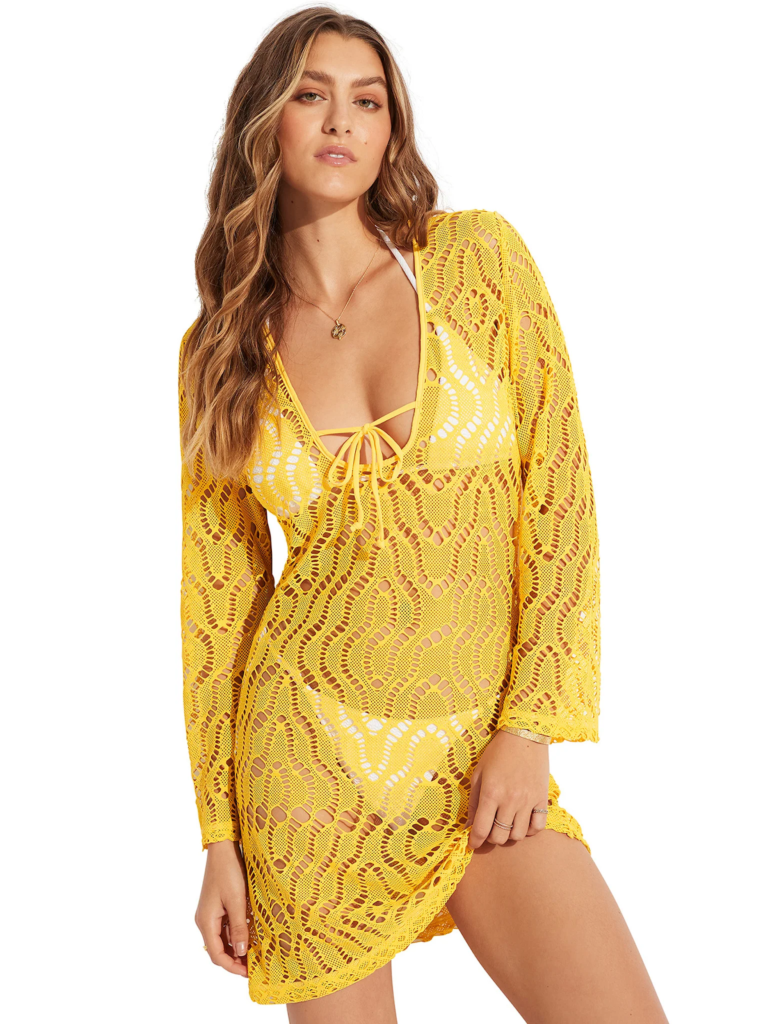 Modella in tunica da spiaggia gialla e bikini bianco