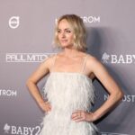 La supermodella Amber Valletta posa con un abito con piume