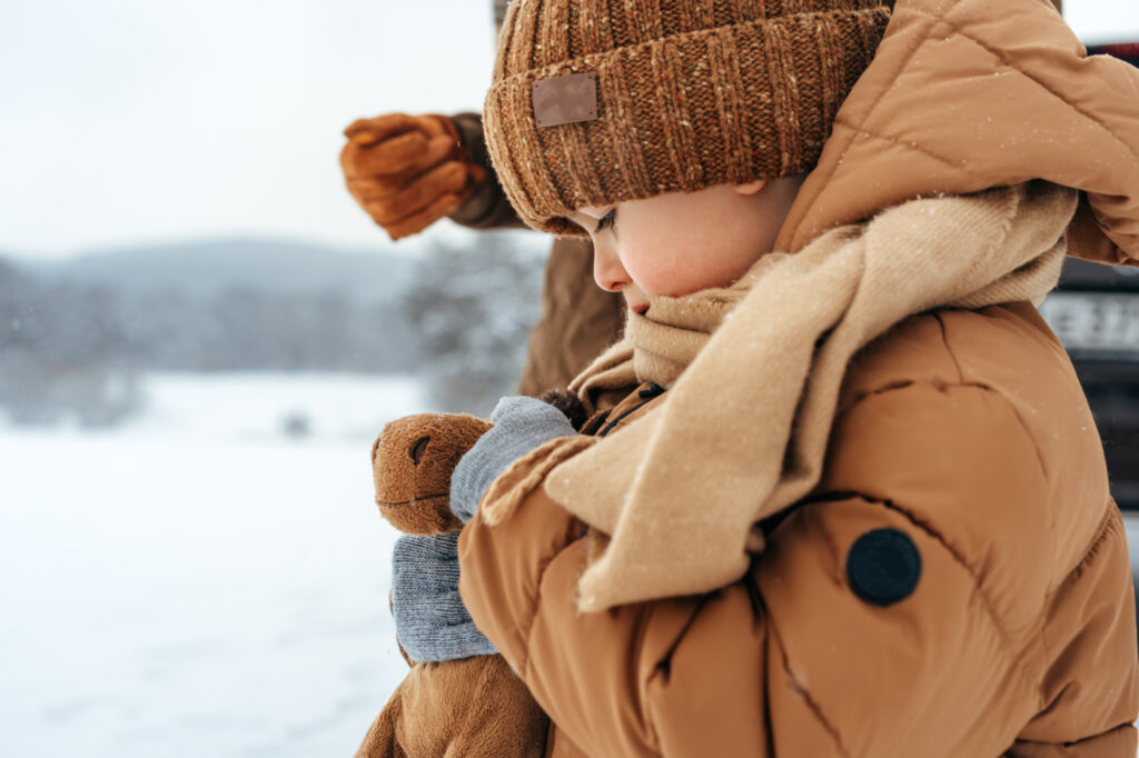 Un bambino con addosso un piumino beige per bambini.