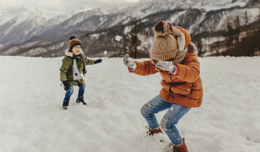 Bambini che giocano con la neve indossando giacche invernali per bambini.