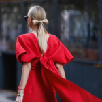 come vestirsi per natale - donna in un elegante abito lungo rosso con fiocco sul retro