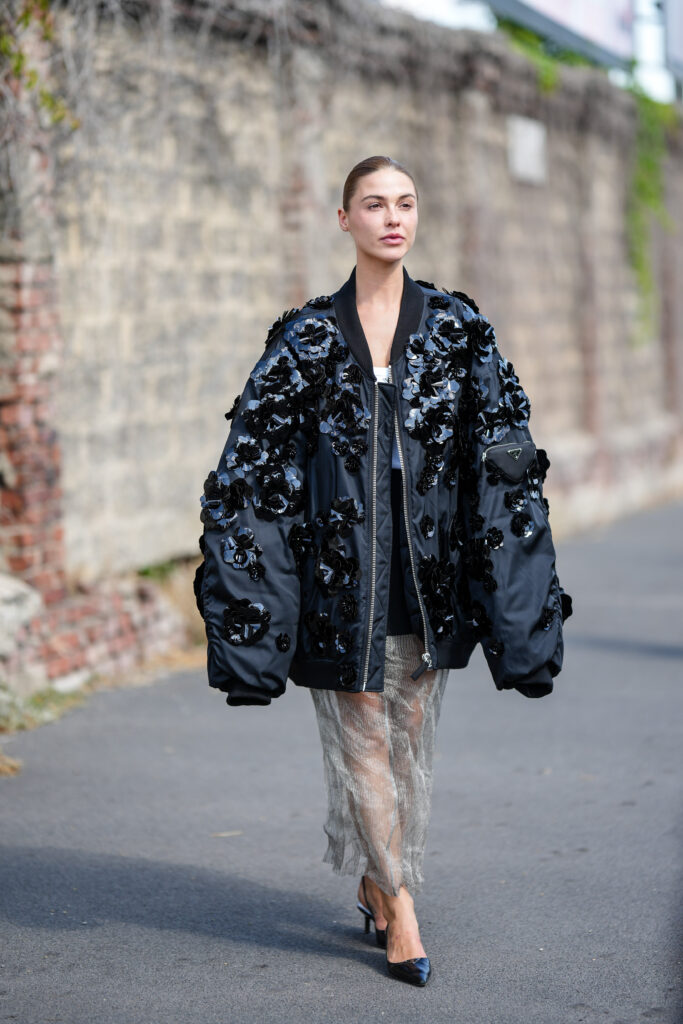 Modella in bomber nero con fiori applicati