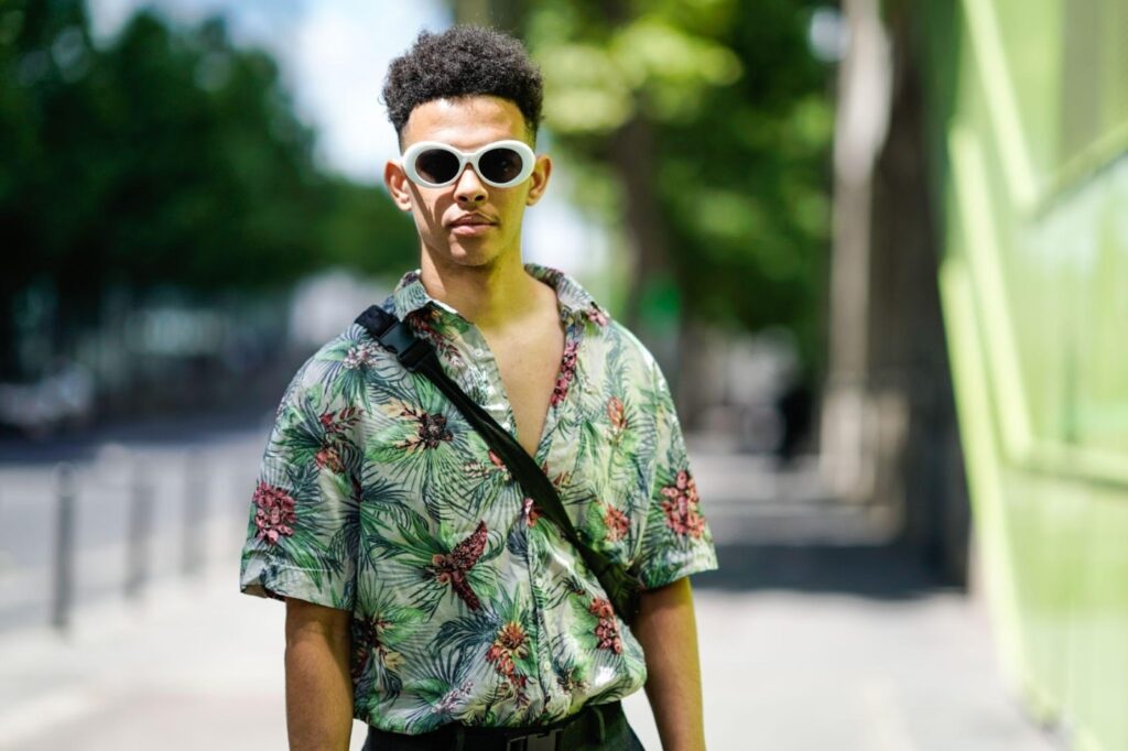 Un uomo indossa una camicia hawaiana e occhiali da sole