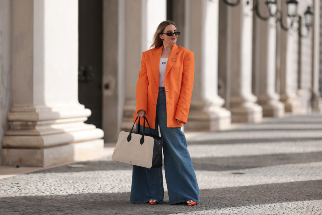 Pantaloni oversize, outfit con jeans molto ampi sulle gambe e blazer oversize in un vivido color arancione